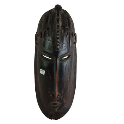 un vieux masque en bois représentant un visage noir sur fond blanc