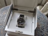 a watch in a box on a table by a window