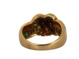 an image of a close up of a gold ring with green stones