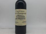 une bouteille de vin « Château Marbust » posée sur une surface blanche