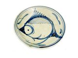 une assiette bleue et blanche ornée d'un motif de poisson