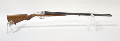 gros plan d'un fusil posé sur un support sur une surface blanche