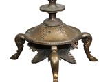 an antique brass candle holder with a bird on top of it