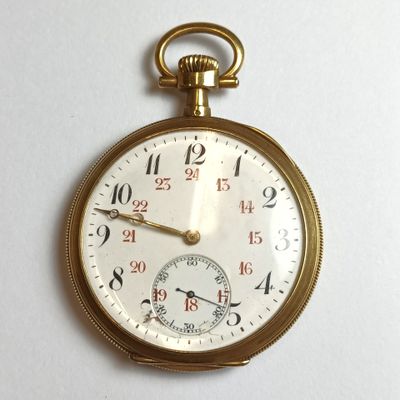 a close up of a gold pocket watch on a white surface