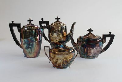 four pieces of art glass tea set on a white surface