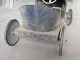 an old toy car sitting in the middle of a room