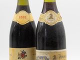 deux bouteilles de vin posées l'une à côté de l'autre sur une surface blanche