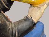 une statue représentant un homme tenant une banane à la main