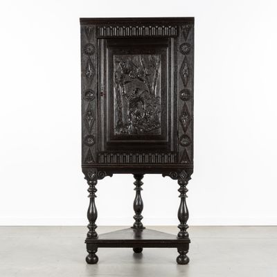 une vieille armoire en bois dont la façade est ornée de motifs sculptés
