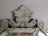 a mirror that has a silver frame with a bird on it