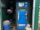 a blue gas pump in the back of a green building