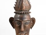 a close up of a wooden head with a crown on it