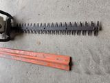 a chainsaw and a ruler laying on the ground