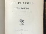 un livre ouvert posé sur une étagère en bois, à côté d'une pile de livres