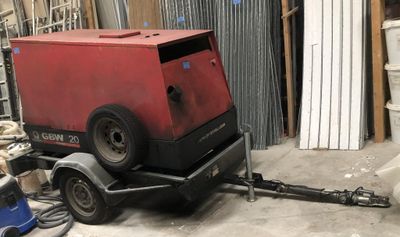 a red machine that is sitting on a trailer