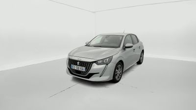 Une voiture argentée est garée dans une pièce blanche au sol blanc.