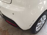 the rear end of a white car with a sticker on it ' s bumper