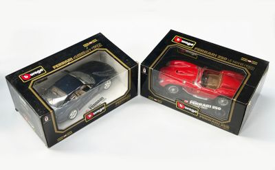 deux petites voitures posées dans une boîte sur une surface blanche