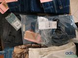 several pairs of jeans are packed in plastic bags on the floor