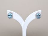 pair of blue topaze and white topaze earrings on a white stand
