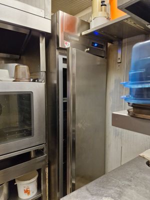stainless steel ovens in a commercial kitchen with pots and pans on the counter