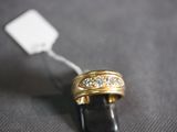 a gold ring with diamonds on it on a black surface