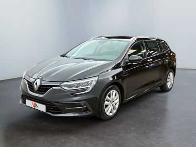 Une voiture noire est garée dans une pièce aux murs blancs.