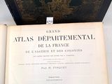 un livre ouvert posé sur une table blanche, à côté d'un livre noir