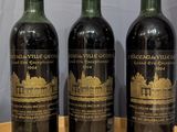 three bottles of wine are lined up on a wooden table