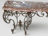 an old iron table with a marble top sitting on a white surface