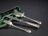 trois fourchettes et deux cuillères dans un étui vert