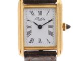 a close up of a gold wrist watch with roman numerals