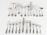 a lot of silverware on a white table