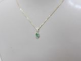 a white mannequin with a green necklace on it
