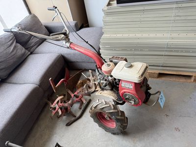 un petit tracteur rouge posé par terre