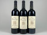 three bottles of red wine sitting next to each other on a table