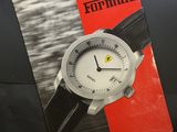 un gros plan d'un livre posé sur une table, sur lequel se trouve une montre