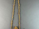 a gold necklace with a cupcake pendant and a pair of earrings