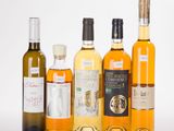 several bottles of wine are lined up on a white surface
