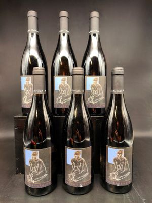 six bouteilles de vin sont alignées sur une table