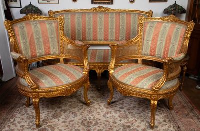 trois chaises et un canapé dans une pièce avec un tapis