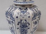 a blue and white vase with a lid on a table