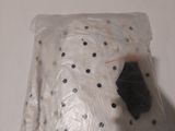 a plastic bag with a black object in it on a table