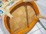 a wooden chair with a basket on it on a tiled floor