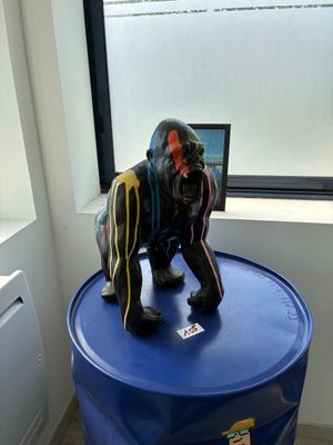 une statue représentant un gorille assis sur un tonneau