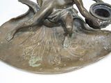 a statue of a woman sitting on a leaf holding a pot