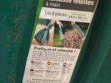 a green trash can with a tag attached to it
