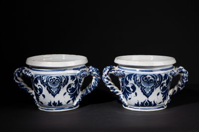 pair of blue and white vases with handles on a black surface