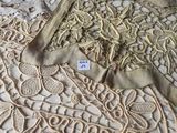beaucoup de napperons sur un lit, avec une étiquette dessus