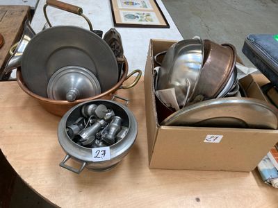 de nombreuses casseroles et poêles posées sur une table, accompagnées d'une étiquette de prix